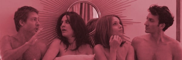 Dos parejas hablando entre sí sobre fondo rosa