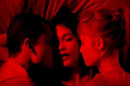 Hombre con dos mujeres foto de cabeza fondo rojo